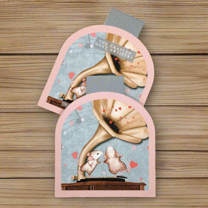 
                  
                    Two arched shaped magnetic bookmarks showing the front and back of two cute mice dancing on a gramophone with hearts all around them
                  
                