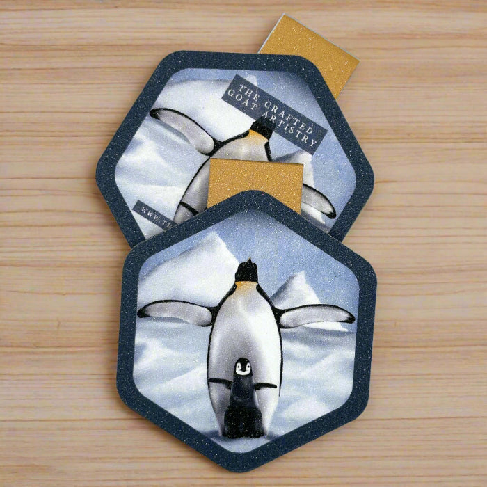 
                  
                    Two hexagon shaped magnetic bookmarks showing the front and back of baby penguin with parent in snowy iceberg scene
                  
                