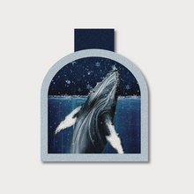  A picture of Humpback Whale coming out of the water with snowflakes on an arch shaped magnetic bookmark